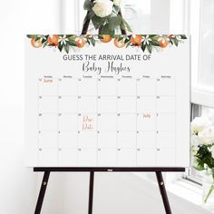 a white calendar with flowers on it sitting next to a flower vase and window sill