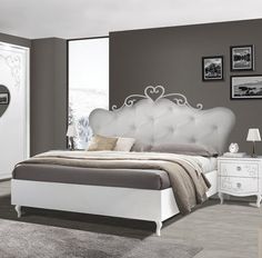 a white bed sitting in a bedroom next to a dresser