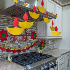 the kitchen is decorated in bright colors and has hanging decorations on the stove top, along with flowers