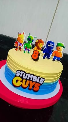 a birthday cake with the number 8 on it and toy figures in front of it