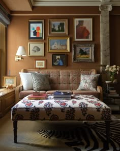 a living room filled with furniture and framed pictures on the wall above it's coffee table