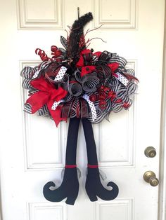 a door hanger decorated with black and red ribbons, stockings and boots for halloween