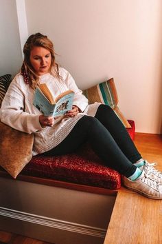 a woman sitting on a bench reading a book