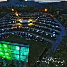 an aerial view of a parking lot at night with cars parked in the lot and lights on