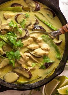 a skillet filled with chicken, mushrooms and cilantro in a green sauce