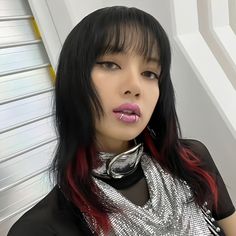 a woman with long black hair wearing a silver scarf and pink lipstick on her lips