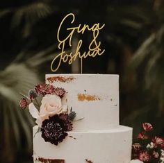 a white wedding cake with flowers and the words the daniels on top