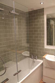 a bathroom with a tub, sink and mirror