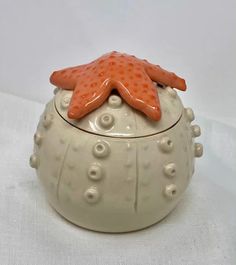 a ceramic container with an orange starfish on top