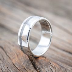 a wedding ring sitting on top of a piece of wood with a textured finish