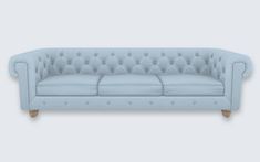 a light blue couch sitting on top of a white floor next to a gray wall