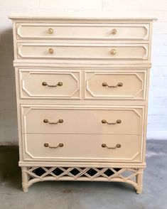 a white dresser with gold handles and drawers