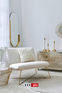 a living room with white furniture and gold accents on the walls, along with a large mirror