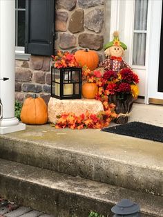 pumpkins and gourds are sitting on the steps in front of a house