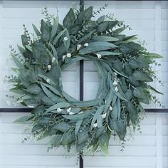 a wreath with white flowers and green leaves