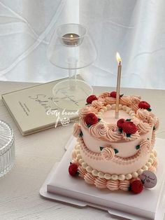 a three tiered cake sitting on top of a white plate next to a candle