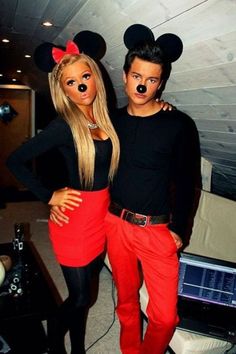 two people dressed up as mickey mouse and minnie mouse, posing for a photo together