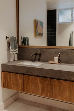 a bathroom with two sinks and a large mirror above the sink is made of wood