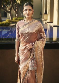 a woman in a brown sari and matching jewelry