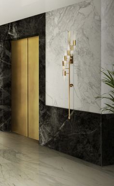 an instagramted photo of a bathroom with marble walls and flooring, including a gold - plated door