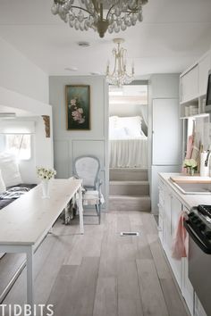 a white kitchen and dining room with chandelier