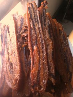 several strips of meat sitting on top of a cutting board