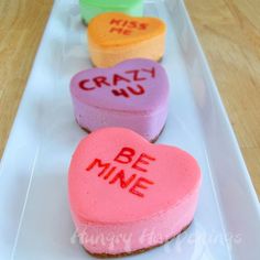 three conversation hearts on a white plate with the words crazy up and be mine written on them