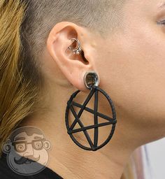 a woman with blonde hair wearing large black hoops and an earring that has a pentagramil on it