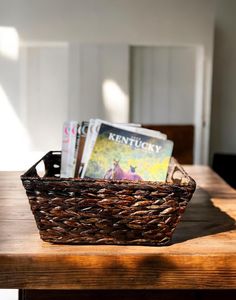 a wooden table topped with a basket filled with books