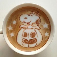 a cup of coffee with a drawing of a pumpkin on it's face in the shape of a dog