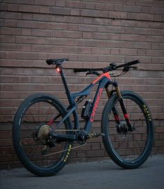 a bike parked in front of a brick wall