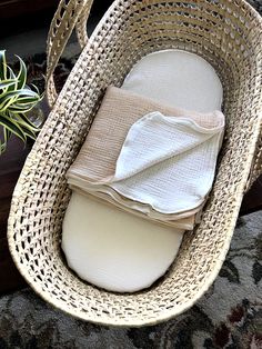 a wicker basket with folded napkins in it next to a potted plant