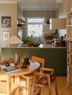 a table and chairs in a room with bookshelves on either side of the table