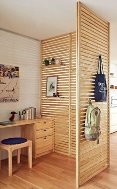 a room divider made out of wooden slats with a bag hanging on it