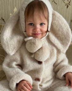 a baby in a bunny costume sitting on a couch