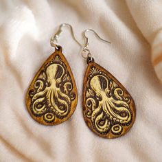 Handmade wood set of engraved octopus earrings with beach vibes tropical nautical theme. Beautiful and unique octopus earrings are dangle drop shape, nice and light for easy wearing. Would go beautifully with other nautical or boho style fashion. Wear casual or formal. Beach Themed Earrings, Handmade Bohemian Jewelry For Her, Handmade Bohemian Jewelry Gift For Her, Personalized Bohemian Jewelry, Handmade Bohemian Jewelry As A Gift For Her, Unique Brown Earrings For Gift, Adjustable Drop Earrings As Gift For Her, Handmade Brown Dangle Jewelry, Personalized Ocean-inspired Jewelry Gift