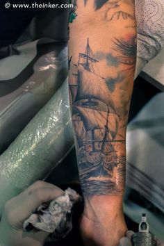 a man's arm with a ship on it