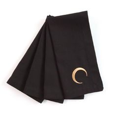 three black napkins with gold crescent embroidered on them