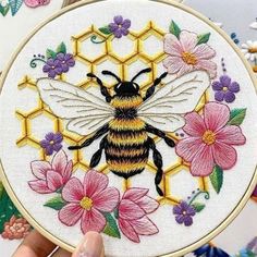 a hand embroidered bee with flowers on it