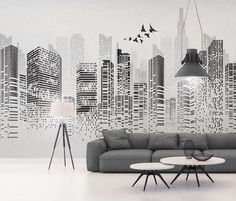 a living room with a couch and table in front of a city skyline wall mural