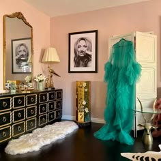 a living room filled with furniture and pictures on the wall next to a dresser in front of a mirror