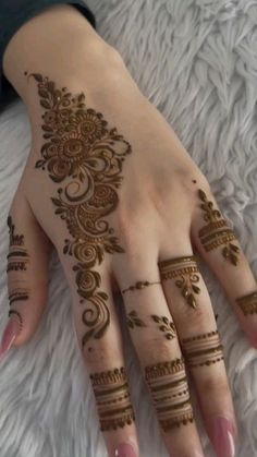 a woman's hand with henna tattoos on it