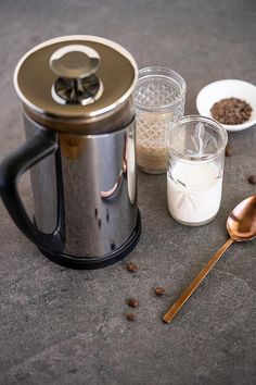 a coffee maker and spoons are sitting on the ground