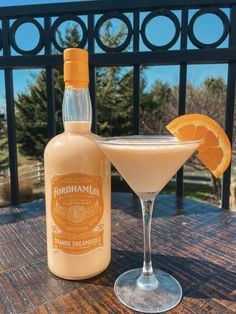 a bottle of orange liqueur next to a glass with an orange slice on the rim