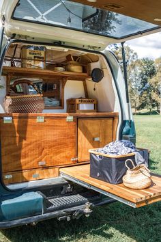 the back end of an open van with its trunk and shelves full of items in it