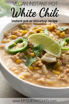 a bowl of white chili with limes and cilantro