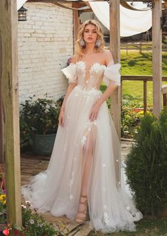 a woman in a white wedding dress posing for the camera