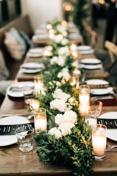 a long table is set with candles and flowers on it for an elegant dinner party