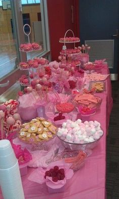 a pink table topped with lots of desserts