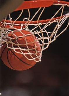 a basketball going through the net in front of a black and red background with the letter n on it